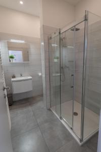 萨格勒布Main Square Dream Apartment的一间带玻璃淋浴和水槽的浴室