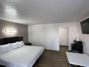 安纳海姆安纳海姆奥朗热6号酒店的酒店客房设有床、桌子和窗户。