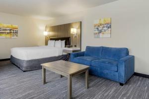 伦顿Best Western Plus Renton Inn的酒店客房,配有床和蓝色的沙发