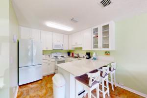 巴拿马城海滩Wendwood Condominiums F2的厨房配有白色橱柜和白色冰箱。