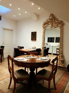 特伦托B&B S. Trinità 18 Suites & Rooms的一间带桌子和镜子的用餐室