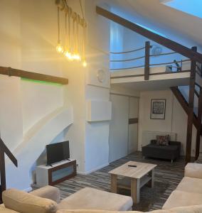 科马尔诺Bella Penzion的客厅设有阁楼,配有沙发和桌子