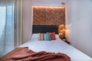 坎布里尔斯Vestal Suites Domo的卧室配有一张白色大床和床头板