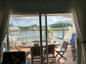 Jolly HarbourSunny Villa in the Marina - Excellent Water Views的阳台配有桌椅,享有水景。