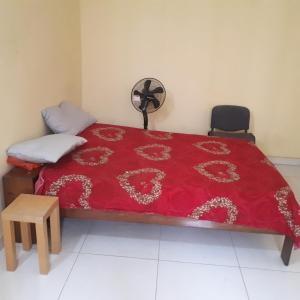 KammbaZAC MBAO - Cité enseignants的一间卧室配有一张红色床罩的床