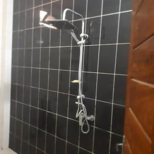 KammbaZAC MBAO - Cité enseignants的浴室铺有黑色瓷砖,设有淋浴。