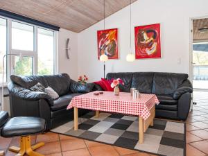 Nørby8 person holiday home in Ringk bing的客厅配有黑色真皮沙发和桌子