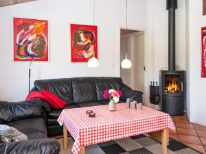 Nørby8 person holiday home in Ringk bing的客厅配有黑色真皮沙发和桌子