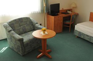 沃尔夫斯堡爱特多富茹穆凯纳酒店的一间位于酒店客房内的带沙发和桌子的房间