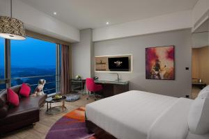 深圳深圳硬石酒店的一间卧室配有一张床、一张桌子和一张沙发