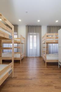 菲盖拉-达福什Dude Beach Hostel的客房设有四张双层床和窗户。