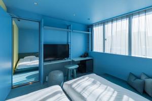东京toggle hotel suidobashi TOKYO的蓝色的房间,配有床和电视