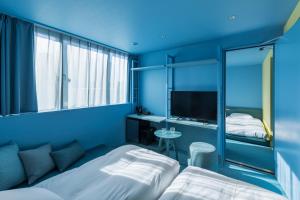 东京toggle hotel suidobashi TOKYO的蓝色的客房配有两张床和电视