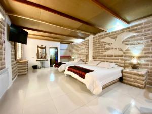 乌尤尼Casa de Sal - Salt Hotel的一间卧室设有两张床和砖墙