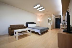 仁川市普莱姆宾馆的一间卧室配有一张床、一张沙发和一台电视