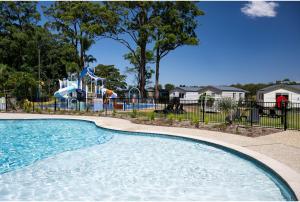 坦卡里福斯特探索公园度假酒店的公园内的游泳池,带游乐场