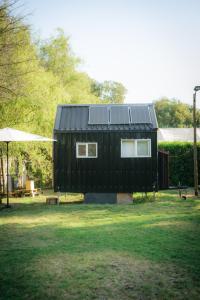 伊斯拉德迈波Tiny House Remanso del Espíritu的一座黑色房子,上面有太阳能电池板