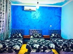 亚喀巴Galaxy Apartments的蓝色墙壁客房的两张床