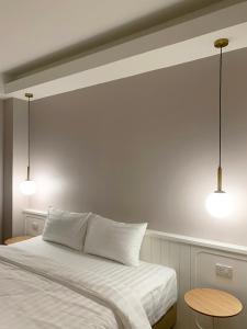 帕卡农区Moon House BKK Room 3B的一间卧室配有一张带两个灯的床