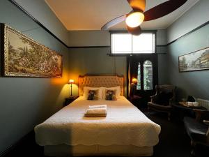 黑荒地The Boutique Hotel Blue Mountains的一间卧室配有一张床和吊扇
