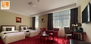 杜尚别Hotel Shumon的酒店客房设有两张床和窗户。