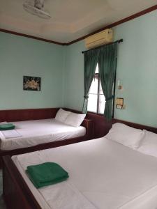 涛岛塔诺特贝家庭度假酒店的带窗户的客房内的两张床