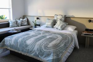 悉尼Beach Road Hotel的一间卧室配有一张大床,提供蓝白色的毯子