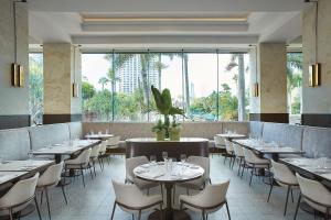 黄金海岸JW Marriott Gold Coast Resort & Spa的餐厅设有桌椅和大窗户。