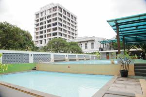 棉兰棉兰大酒店的一个空的游泳池,后面有一座高大的建筑