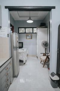 外南梦Agus Hidden Homestay - Banjar Sweet Village的带冰箱的厨房和配有床的房间