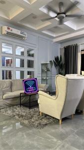 丹那美拉Aisyah homestay的客厅配有沙发和椅子
