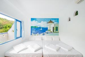 小琉球岛白灯楼旅宿的白色的客房设有白色的床和窗户。