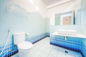小琉球岛白灯楼旅宿的蓝色瓷砖浴室设有卫生间和水槽
