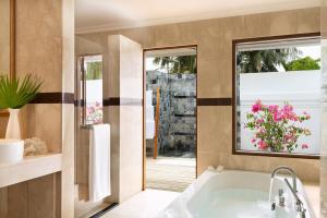 马累Kurumba Maldives的带浴缸和窗户的浴室