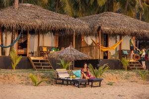卡纳科纳Bamboo Yoga Retreat的坐在海滩长凳上的女人