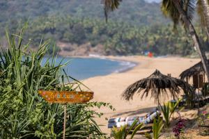 卡纳科纳Bamboo Yoga Retreat的带有读写字体的标志的海滩