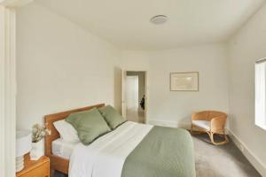 悉尼Oceanfront Tamarama Apartment: Best View in Sydney的白色卧室配有床和椅子