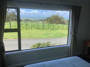 奥克兰Kaiaua Bayview Farm Apartment的卧室的窗户,享有田野美景