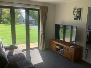 奥克兰Kaiaua Bayview Farm Apartment的客厅配有平面电视和沙发。
