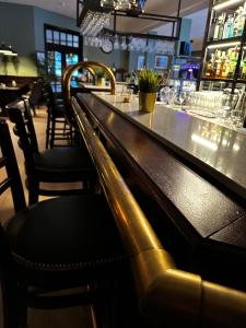 BømloBømlo Hotell的餐厅内的酒吧配有椅子和柜台
