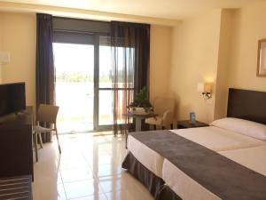维拉Hotel Adaria Vera的酒店客房设有一张床和一个大窗户