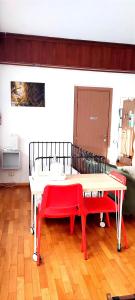 安科纳B&B L'Assiolo的一间设有桌子和两个红色长椅的房间