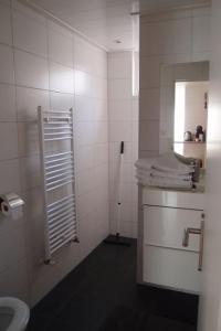 海滨诺德韦克Zomerhuis Toda Cambia dicht bij strand的白色的浴室设有水槽和卫生间。