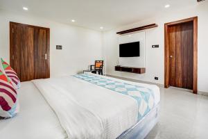 布巴内什瓦尔Sayhallo Prime Residency的一间卧室配有一张大床和电视