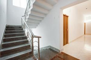 KhandagiriSuper Collection O Sayhallo Hillside Magnum的白色墙壁和木门房子的楼梯