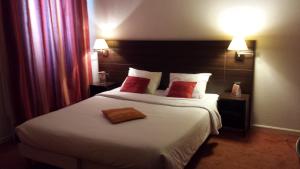 佩皮尼昂urban by balladins Perpignan的酒店客房配有一张带红色枕头的大床