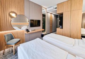 普鲁什库夫阿卡斯酒店的一间卧室配有两张床、一把椅子和镜子