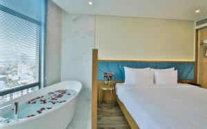 岘港岘港圣马力诺精品酒店的酒店客房配有一张床和浴缸。