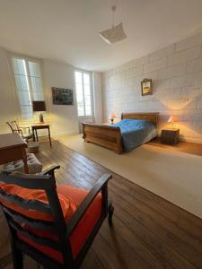 Mortagne-sur-GirondeLa Maison du Port的一间卧室,卧室内配有一张床和一把椅子
