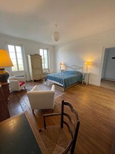 Mortagne-sur-GirondeLa Maison du Port的一间卧室,卧室内配有一张床和椅子